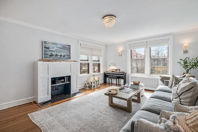 living room with radiator heating unit, wood finished floors, plenty of natural light, and baseboards