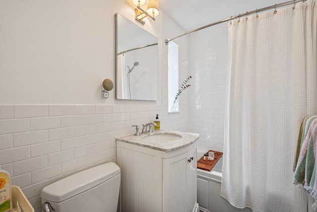 bathroom featuring vanity, tile walls, shower / tub combo, and toilet