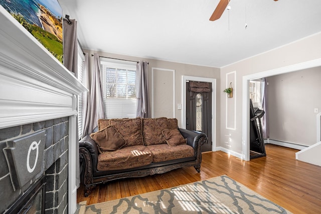 living room with ceiling fan, wood finished floors, baseboards, and a baseboard radiator