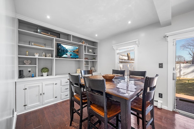 dining room featuring dark wood-style floors, baseboard heating, and a wealth of natural light