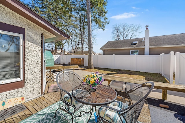 deck with a fenced backyard and outdoor dining space