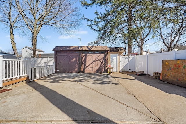 garage with a gate, fence, and a shed