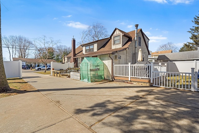 exterior space with an outbuilding, fence, a residential view, a shingled roof, and a chimney