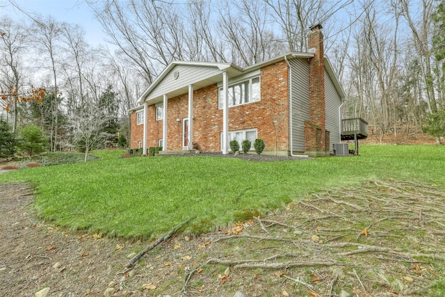 view of property exterior with a lawn, brick siding, central AC, and a chimney