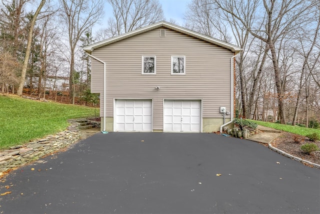 view of home's exterior with aphalt driveway and a garage