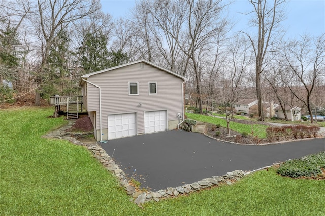 view of home's exterior featuring an attached garage, driveway, and a lawn