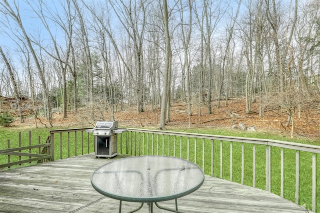 wooden deck featuring grilling area and a lawn