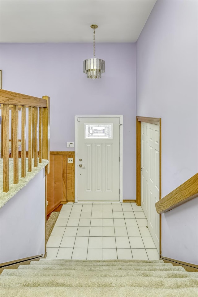 entrance foyer with light tile patterned floors and an inviting chandelier