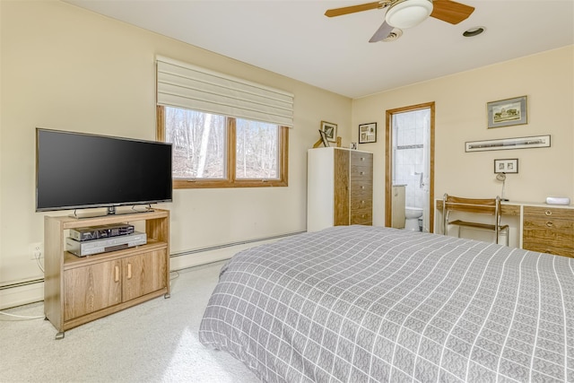 bedroom with baseboard heating, ensuite bath, and a ceiling fan