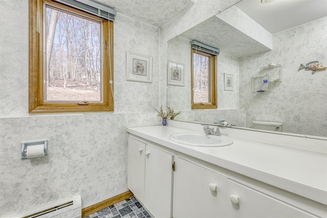 bathroom with baseboard heating, a healthy amount of sunlight, and wallpapered walls