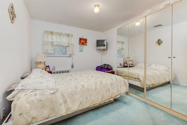 carpeted bedroom featuring a closet and visible vents