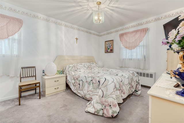 bedroom featuring a notable chandelier, light colored carpet, radiator heating unit, and baseboards