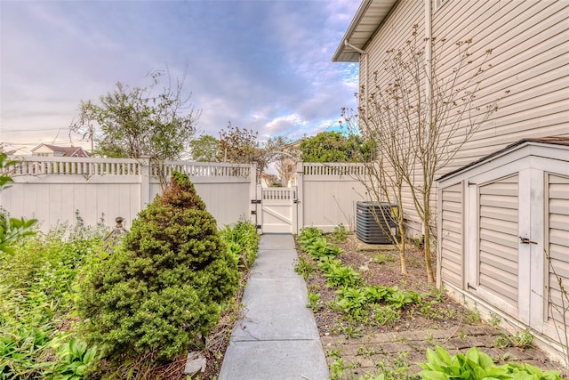 view of yard featuring fence, central AC, and a gate