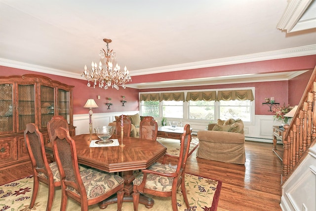 dining space with a wainscoted wall, a healthy amount of sunlight, and wood finished floors