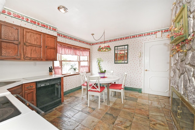 kitchen featuring stone finish flooring, wallpapered walls, black dishwasher, brown cabinetry, and light countertops