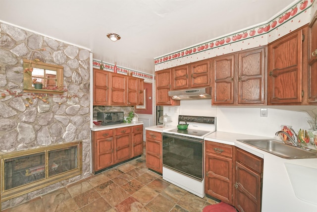 kitchen with electric stove, under cabinet range hood, a sink, a stone fireplace, and light countertops