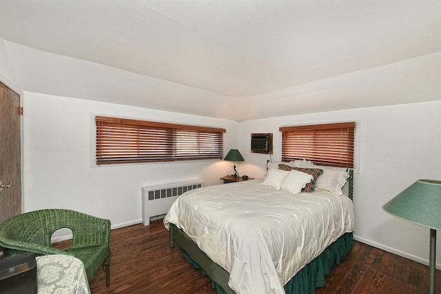 bedroom with baseboards, radiator, wood finished floors, and a wall mounted AC