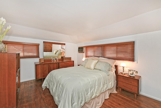 bedroom with wood finished floors, baseboards, and a wall mounted air conditioner