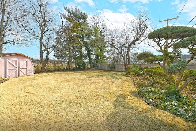 view of yard featuring a storage unit, an outbuilding, and fence