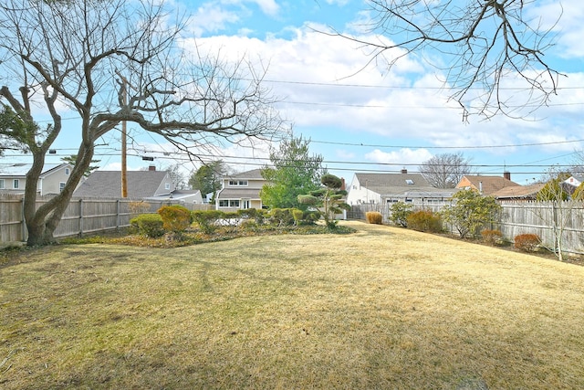 view of yard featuring a fenced backyard and a residential view