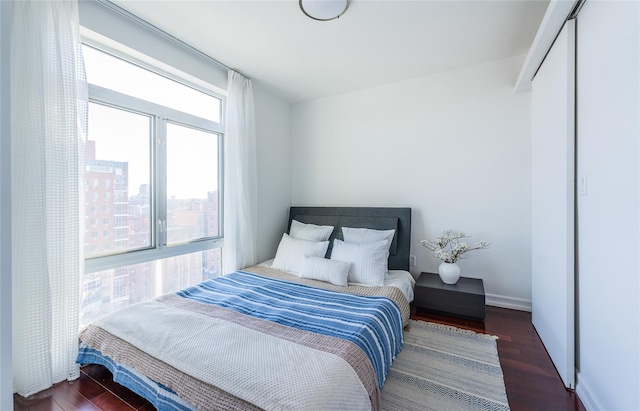 bedroom featuring a view of city and wood finished floors