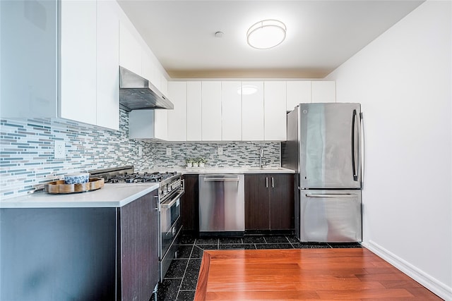 kitchen featuring modern cabinets, backsplash, stainless steel appliances, white cabinets, and wall chimney range hood