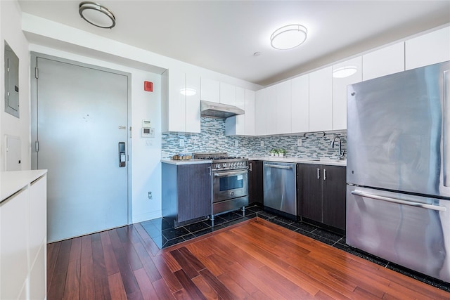 kitchen with dark wood-style flooring, light countertops, under cabinet range hood, appliances with stainless steel finishes, and white cabinetry