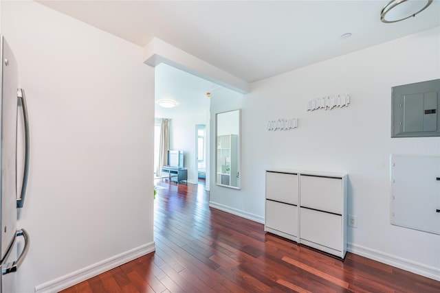 empty room with electric panel, baseboards, and hardwood / wood-style floors