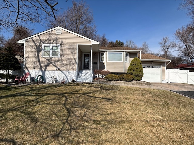 view of front of house with a front lawn, an attached garage, fence, and driveway