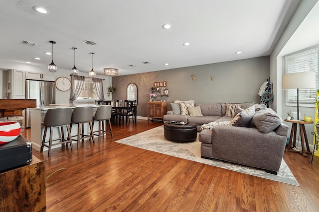 living area featuring recessed lighting, wood finished floors, and visible vents