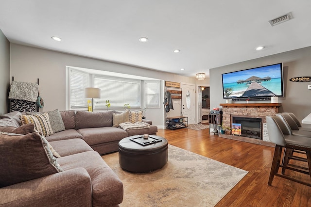 living area featuring visible vents, wood finished floors, recessed lighting, a fireplace, and baseboards