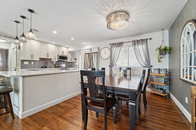 dining area featuring a notable chandelier, recessed lighting, dark wood-type flooring, and baseboards