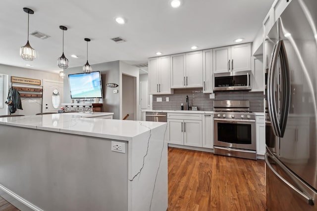 kitchen with visible vents, backsplash, appliances with stainless steel finishes, and a sink