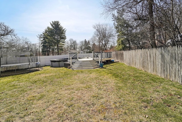 view of yard with a wooden deck, a trampoline, a fenced in pool, and a fenced backyard