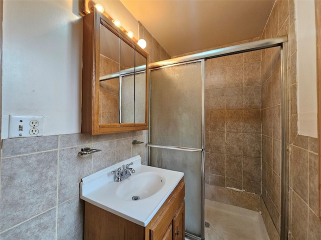 bathroom with tile walls, a stall shower, and vanity