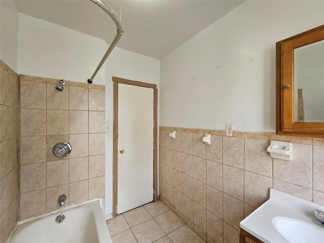 bathroom with tile patterned floors, a wainscoted wall, tile walls, tub / shower combination, and vanity