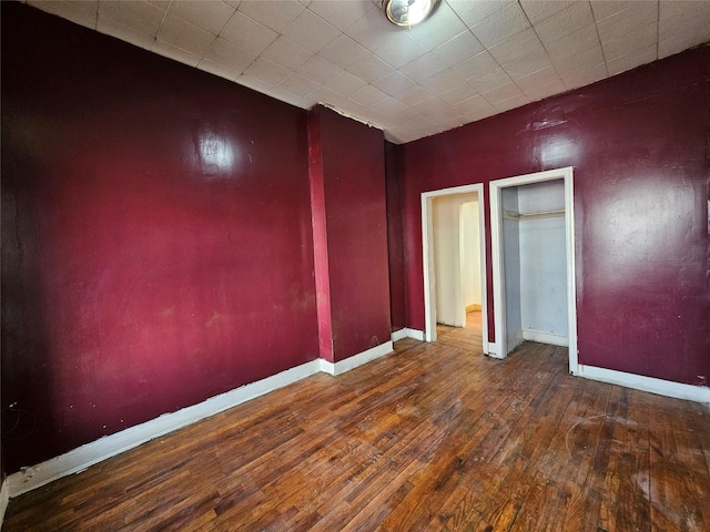 unfurnished bedroom featuring hardwood / wood-style flooring and baseboards