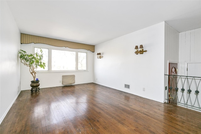 unfurnished room with hardwood / wood-style floors, baseboards, and visible vents