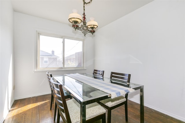 dining room with an inviting chandelier, baseboards, and wood-type flooring