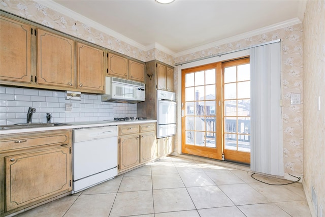 kitchen with white appliances, ornamental molding, a sink, light countertops, and a warming drawer