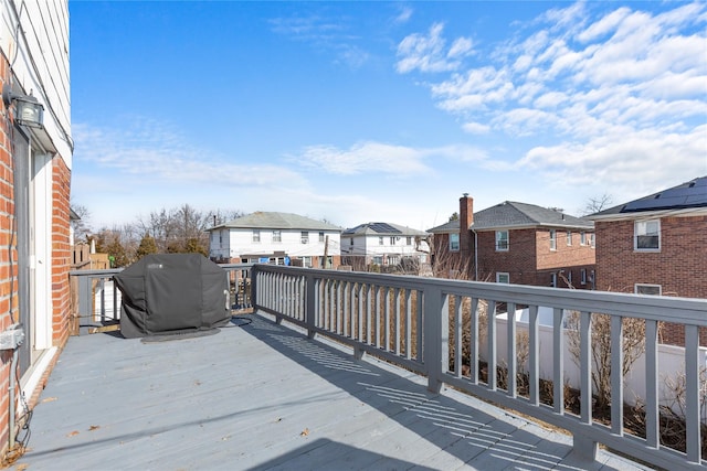 wooden terrace featuring a residential view and a grill