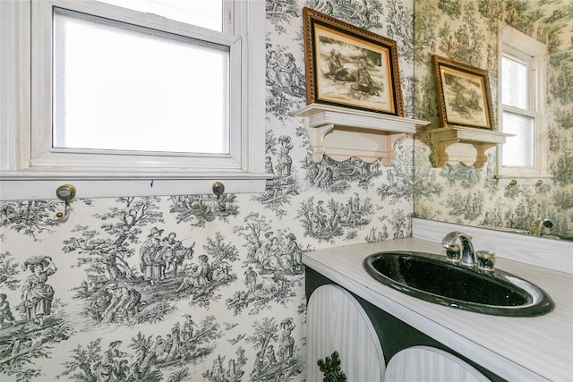 bathroom with vanity and wallpapered walls