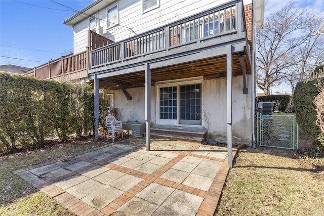 rear view of property featuring entry steps, a patio, and a gate