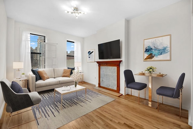 living room featuring baseboards, wood finished floors, and a tiled fireplace