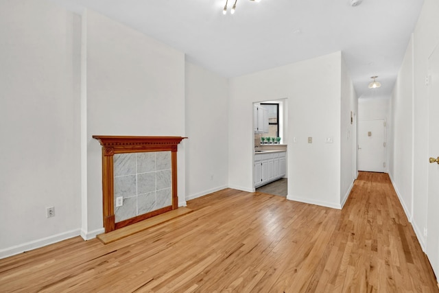 unfurnished living room with light wood-style flooring and baseboards