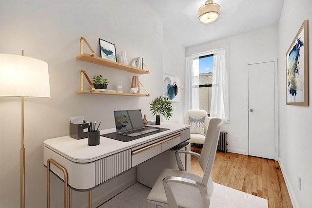 office area with light wood-style flooring and baseboards