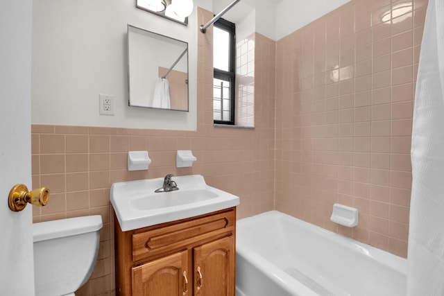 bathroom with shower / bath combo with shower curtain, toilet, tile walls, and vanity