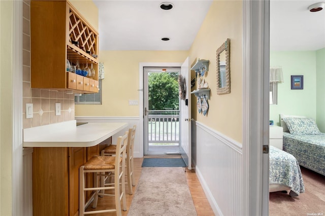 doorway featuring a wainscoted wall and light wood finished floors