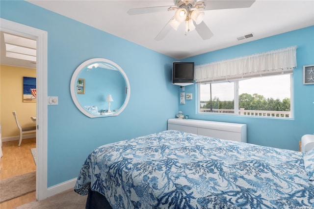 carpeted bedroom with visible vents, baseboards, and ceiling fan