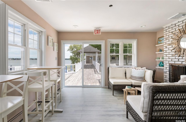 sunroom / solarium featuring visible vents and a brick fireplace